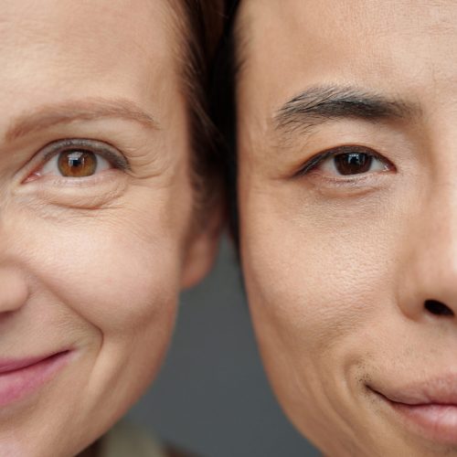 Faces of diverse couple with age difference smiling at camera